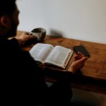 man in black shirt reading book